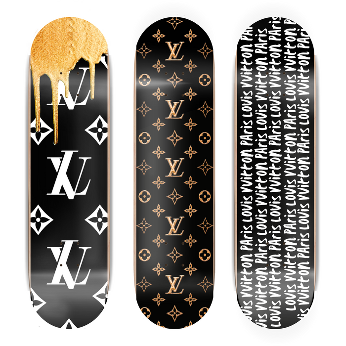 Three skateboard decks with gold and white designs on a black background