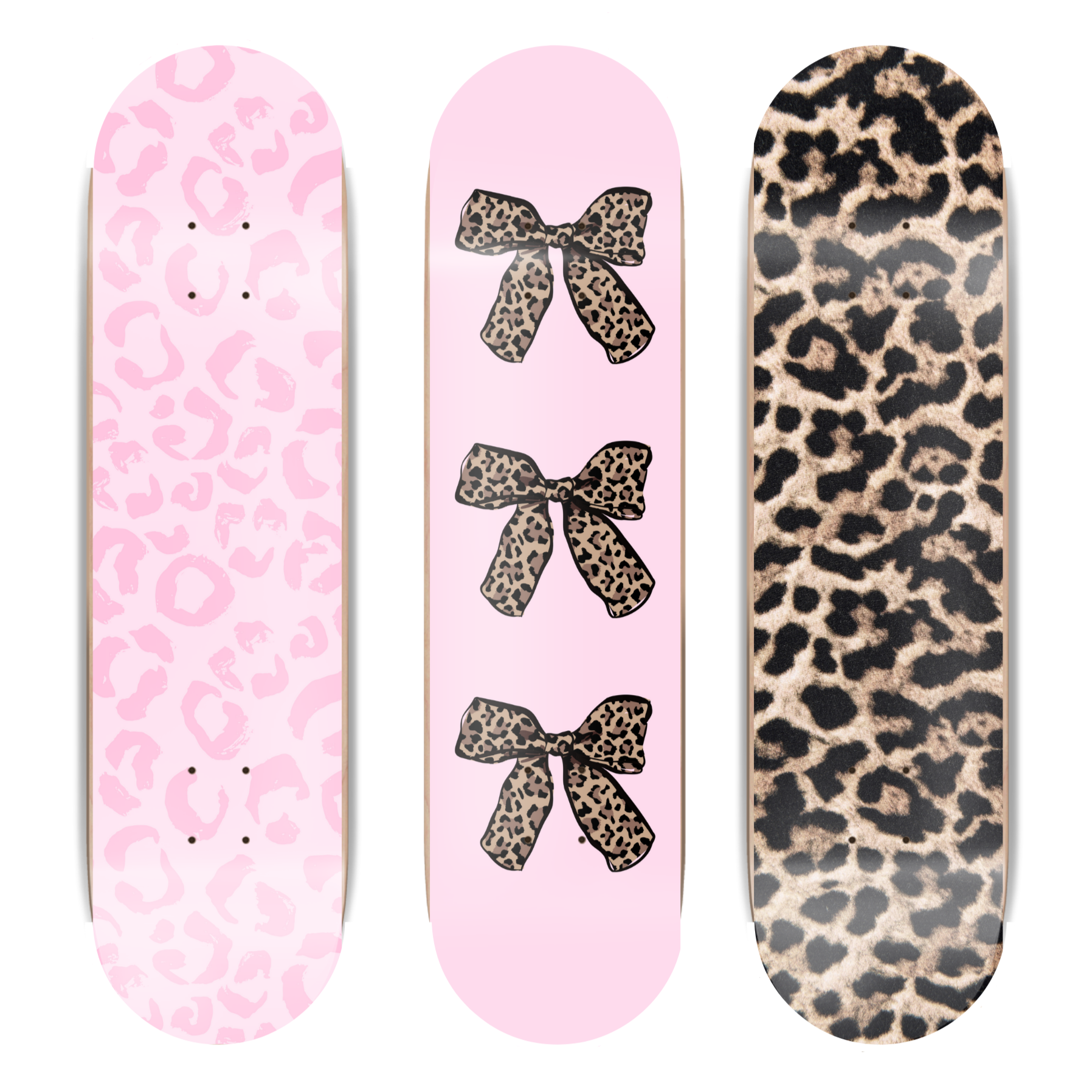 Three skateboard decks with pink leopard print and black bows design on two of them, and a solid leopard print design on the third.
